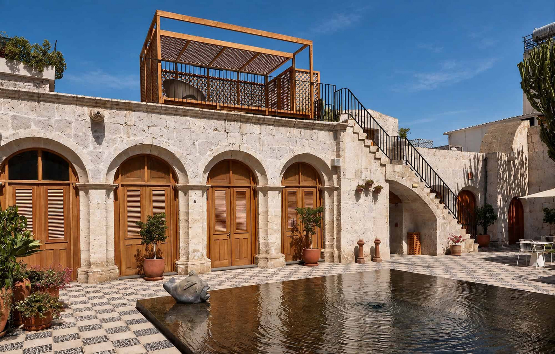 Patio interior con piscina entre paredes históricas en Palacio Guaqui en Arequipa